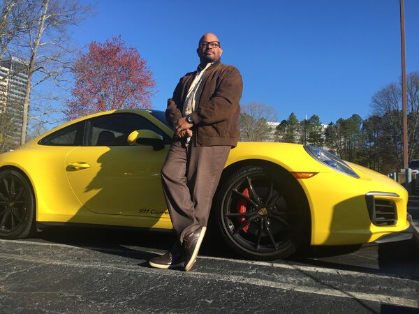 Todd Duncan, a senior editor with the AJC, stands with the Porsche 911 Carrera 4S he used through the Porsche Passport program. RIC WATKINS / AJC