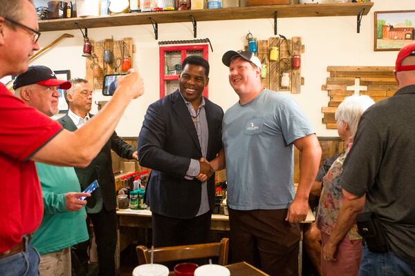 Gainesville resident Josh Brice, right, takes a photo with Republican U.S. Senate hopeful Herschel Walker during a campaign stop in July. Walker often stands patiently at such events to take pictures with a long lines of star-struck fans, many of them wearing his jersey from his days as a football star at the University of Georgia. CHRISTINA MATACOTTA FOR THE ATLANTA JOURNAL-CONSTITUTION.