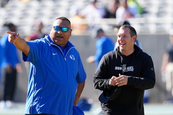 BYU head coach Kalani Sitake, left, talks with Arizona State head coach Kenny Dillingham before an NCAA college football game Saturday, Nov. 23, 2024, in Tempe, Ariz. (AP Photo/Ross D. Franklin)