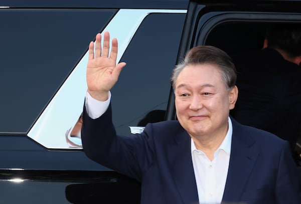 Impeached South Korean President Yoon Suk Yeol greets to his supporters upon his arrival outside of presidential residence in Seoul, South Korea, Saturday, March 8, 2025. (Kim In-chul/Yonhap via AP)