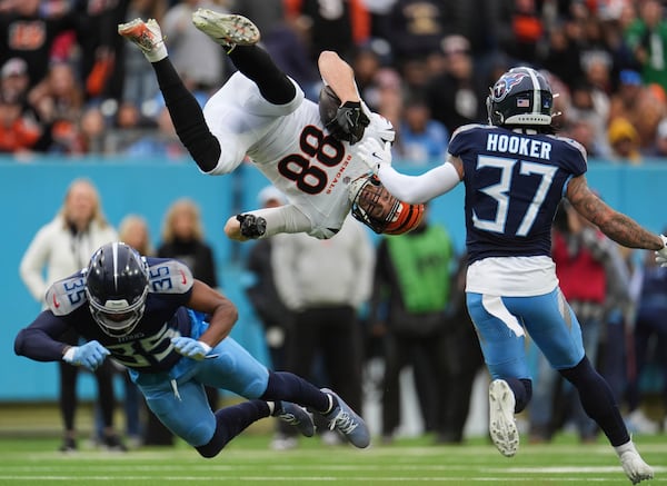 Cincinnati Bengals tight end Mike Gesicki (88) is flipped into the air by Tennessee Titans cornerback Daryl Worley (35) as safety Amani Hooker (37) looks on during the first half of an NFL football game Sunday, Dec. 15, 2024, in Nashville, Tenn. (AP Photo/George Walker IV)