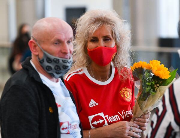 Deb Halleck (right) greets partner Stephen Donnelly after he arrived from the UK Monday, Nov. 8, 2021 at Hartsfield-Jackson Atlanta International Airport. The two had not been able to visit each other due to the U.S. COVID-19 travel ban. (Daniel Varnado/ For the Atlanta Journal-Constitution)

