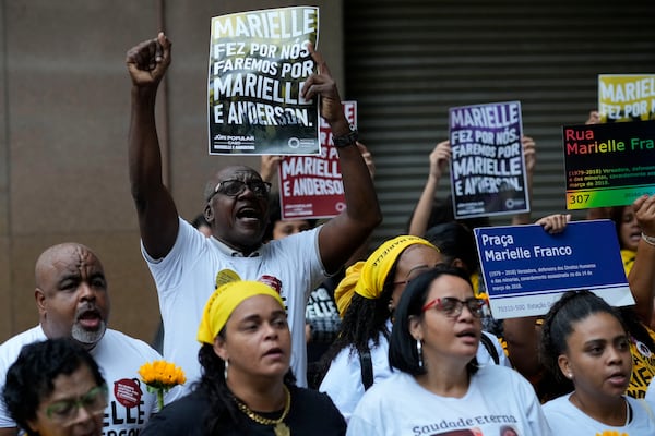 People attend a rally prior to the trial of former Rio de Janeiro city councilwoman Marielle Franco's alleged killers outside the Court of Justice, in Rio de Janeiro, Wednesday, Oct. 30, 2024. (AP Photo/Silvia Izquierdo)