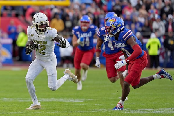 Colorado wide receiver Travis Hunter (12) runs for a first down during the first half of an NCAA college football game against Kansas, Saturday, Nov. 23, 2024, in Kansas City, Mo. (AP Photo/Charlie Riedel)