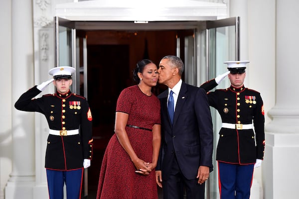 Former president Barack Obama (R) gives Michelle Obama a kiss as they wait for Donald Trump and wife Melania at the White House before the inauguration on January 20, 2017 in Washington, D.C. Trump becomes the 45th President of the United States.   (Photo by Kevin Dietsch-Pool/Getty Images)