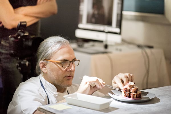 Kyma executive chef Pano I. Karatassos puts the finishing touches on one of the dishes being photographed for his new cookbook. “The project came about from years of people at Kyma saying, ‘You need to do a book,’” he said. CONTRIBUTED BY GALINA JULIANA