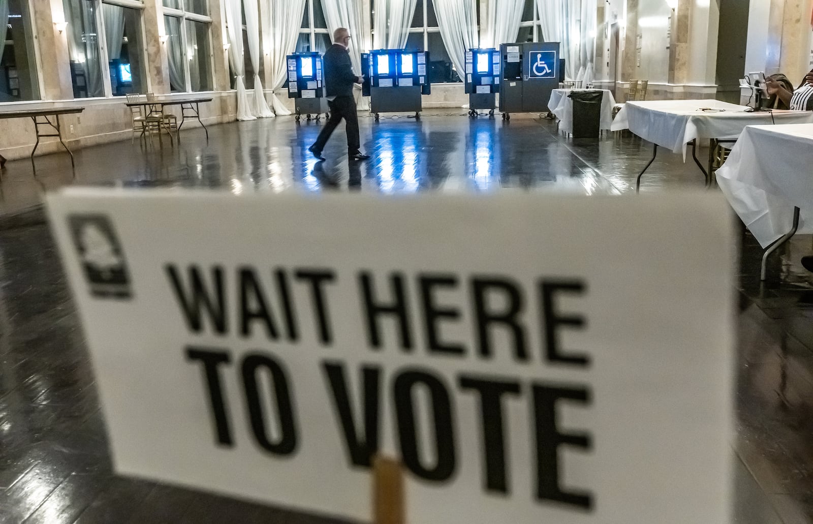 Poll workers stroll through the voting area at Park Tavern in Atlanta in March.