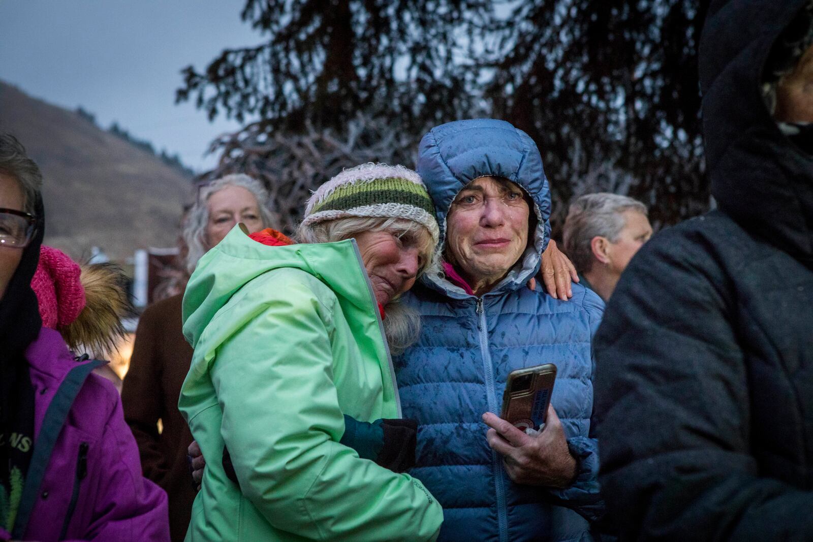 Trina Gioshes comforts Mari Auman as they mourn the loss of grizzly bear No. 399 during a candlelight vigil in Jackson, Wyo., Saturday, Nov. 2, 2024. (AP Photo/Amber Baesler)