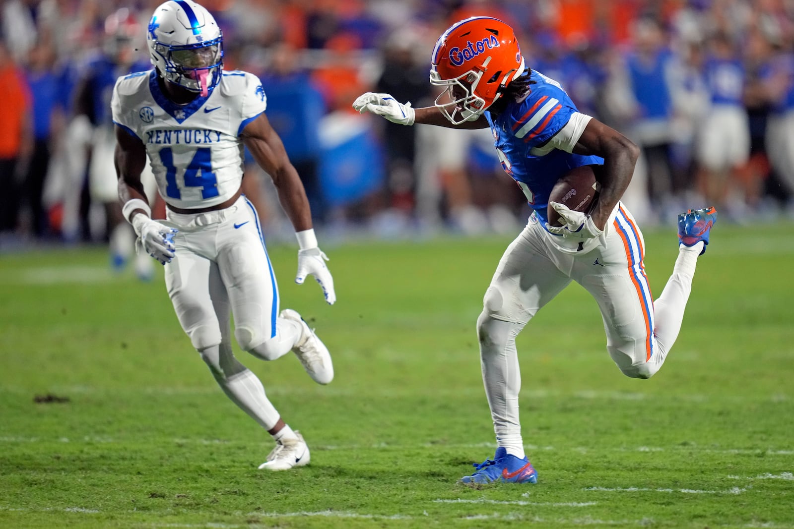 Florida wide receiver Elijhah Badger, right, makes a reception as he runs past Kentucky defensive back Ty Bryant (14) during the first half of an NCAA college football game, Saturday, Oct. 19, 2024, in Gainesville, Fla. (AP Photo/John Raoux)