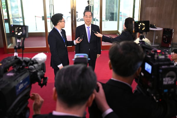 South Korean Prime Minister Han Duck-soo, center, speaks to the media as he arrives at the Government Complex in Seoul Monday, March 24, 2025, after the Constitutional Court dismissed the impeachment of the prime minister. (Jung Yeon-je/Pool Photo via AP)