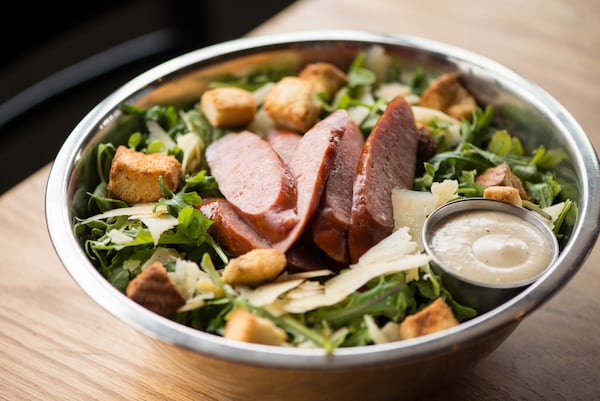 King Barbecue Kale Caesar Salad with baby kale, arugula, shaved parmesan, croutons, and smoked pork sausage. Photo credit- Mia Yakel.