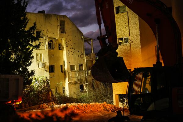 An excavator works at the site where a day before a residential building was hit by a rocket fired from Lebanon, in Haifa, Israel, Monday, Nov. 25, 2024. (AP Photo/Francisco Seco)