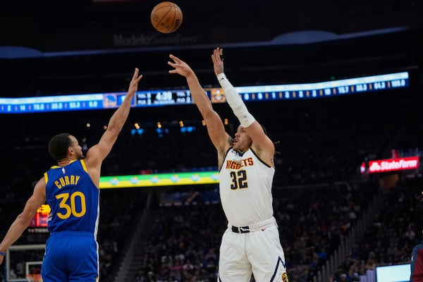 Denver Nuggets forward Aaron Gordon, right shoots a 3-point basket over Golden State Warriors guard Stephen Curry during the first half of an NBA basketball game Monday, March 17, 2025, in San Francisco. (AP Photo/Godofredo A. Vásquez)