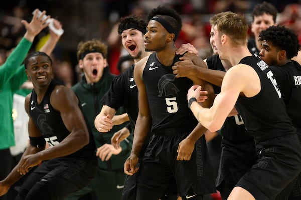 Michigan State guard Tre Holloman (5) and teammates celebrate after he made a game-winning basket to win the game at the buzzer during the second half of an NCAA college basketball game against Maryland, Wednesday, Feb. 26, 2025, in College Park, Md. (AP Photo/Nick Wass)