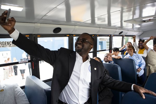 Daniel Blackman, The Region 4 Administrator for the U.S. Environmental Protection Agency (EPA), takes a selfie with members of the Michelle Obama STEM Academy robotics club on a new zero-emission school bus. Blackman and other officials held a press conference at the Michelle Obama STEM Academy in Hampton, Georgia on Wednesday, May 17, 2023., announcing $400 million in grant funding for clean school buses for Clayton County public schools from the EPA. The grants will fund the replacement of diesel school buses with zero-emission school buses. CHRISTINA MATACOTTA FOR THE ATLANTA JOURNAL-CONSTITUTION.