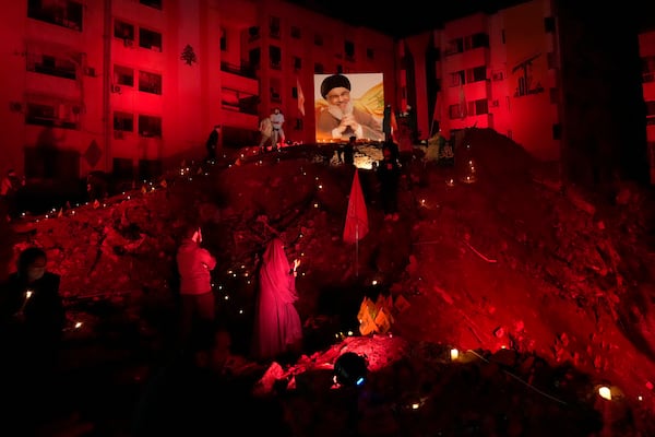 FILE - A woman lights candles at the site where former Hezbollah leader Hassan Nasrallah was killed by Israeli airstrikes in the southern suburb of Beirut, Lebanon, Nov. 30, 2024. (AP Photo/Hussein Malla, File)