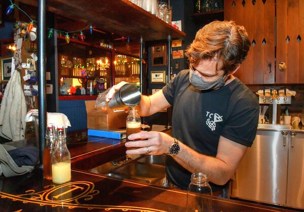 211220 Atlanta, Ga: Ticonderoga Club co-owner Paul Calvert mixes and fills bottles for to-go cocktails made to order from the walk-up window at the Club during a closure due to two staff members testing positive for COVID-19.  (Chris Hunt for The Atlanta Journal-Constitution)