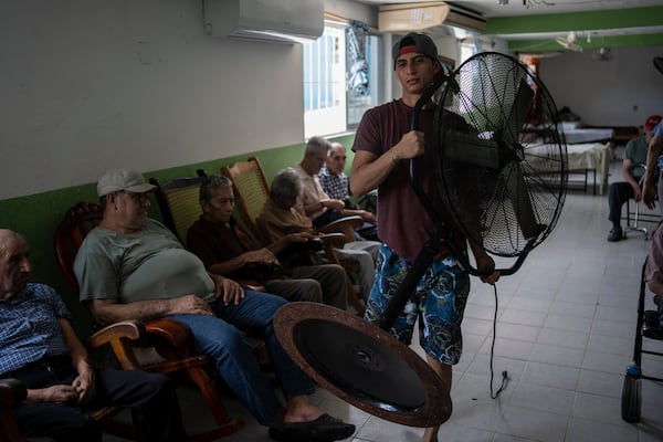 FILE - Humanitarian worker Roger Duvan Lagunes carries a fan into the Cogra, an elderly shelter, in Veracruz, Mexico, on June 16, 2024. (AP Photo/Felix Marquez, File)