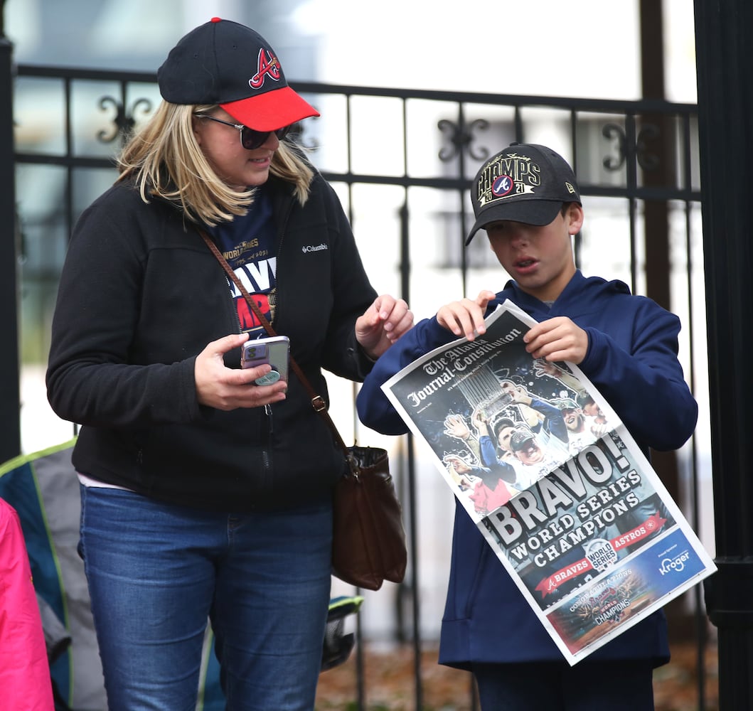 Mason Glenn, right, 10, of Locust Grove, looks at a World Series issue of the AJC along with his aunt, Linsey Floyd, before the Braves' World Series parade in Atlanta, Georgia, on Friday, Nov. 5, 2021. (Photo/Austin Steele for the Atlanta Journal Constitution)