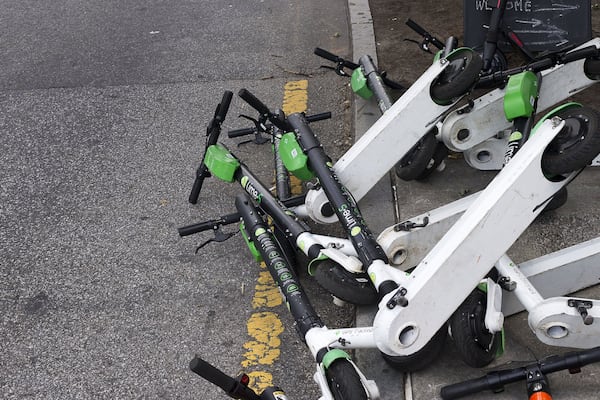 Sharable e-scooters lay knocked in a lane along Centennial Olympics Park Drive. (Alyssa Pointer/alyssa.pointer@ajc.com)