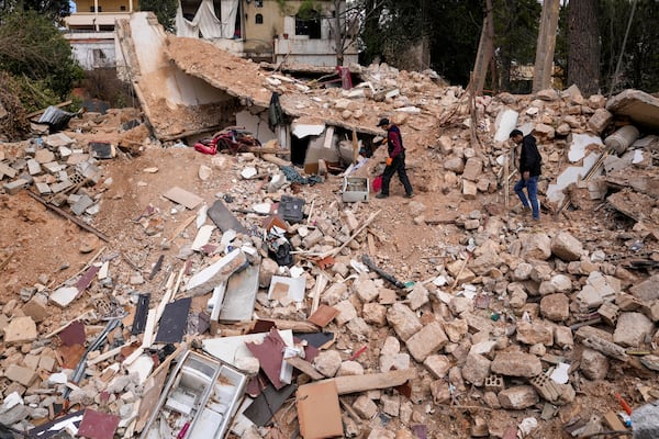 Displaced residents walk on the rubble of their destroyed house in Baalbek, eastern Lebanon, Thursday, Nov. 28, 2024. (AP Photo/Hassan Ammar)