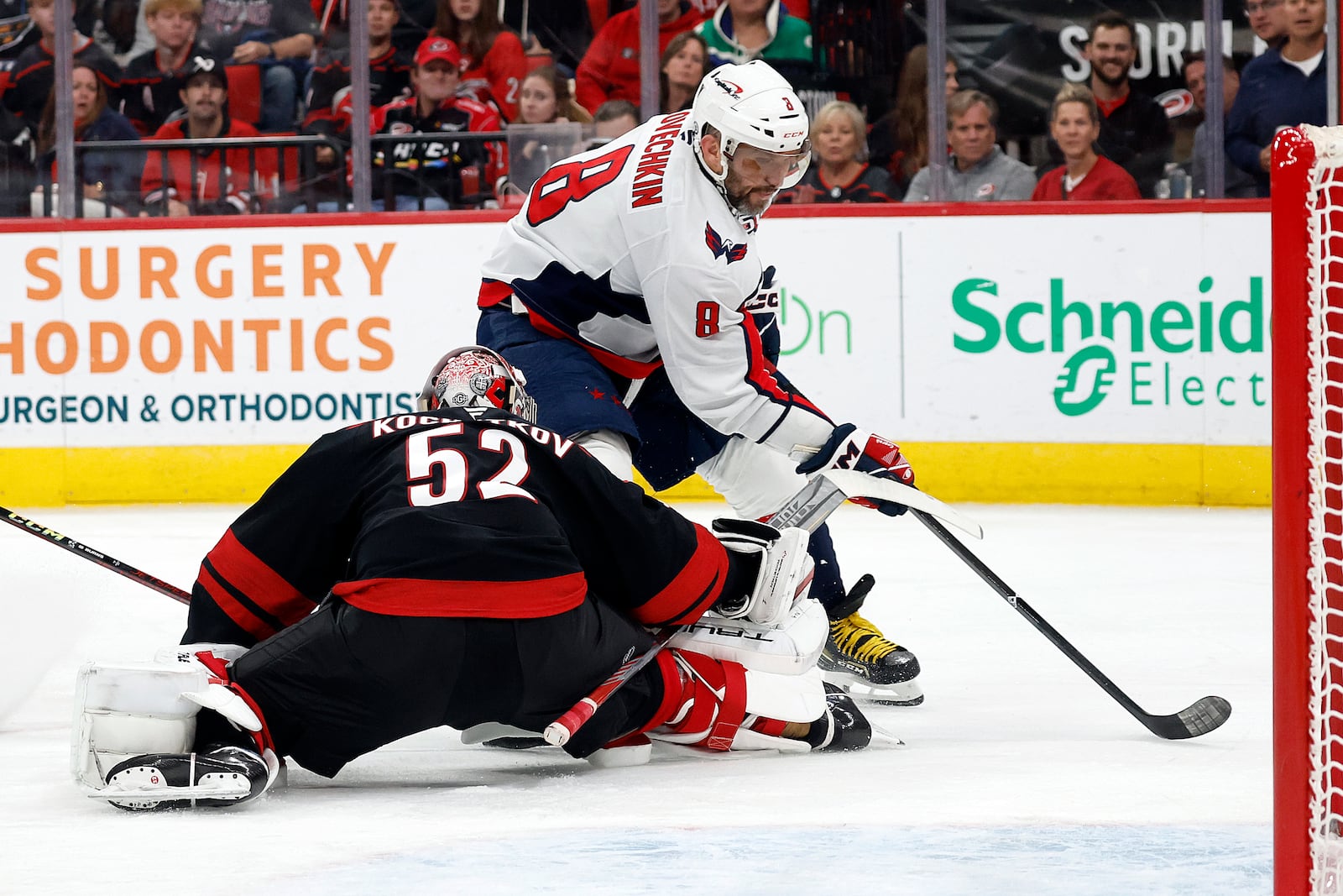 Carolina Hurricanes goaltender Pyotr Kochetkov (52) strips the puck from Washington Capitals' Alex Ovechkin (8) during the third period of an NHL hockey game in Raleigh, N.C., Sunday, Nov. 3, 2024. (AP Photo/Karl B DeBlaker)