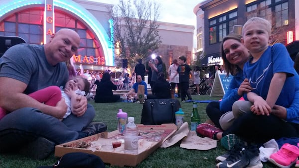 Brent and Kristen Pennington and their kids, of Milton, picnic and listen to a band on the artificial lawn at Avalon. “It’s kind of like a mini Buckhead,” said Kristen Pennington, who used to live in Buckhead before moving to the suburbs. MATT KEMPNER / AJC