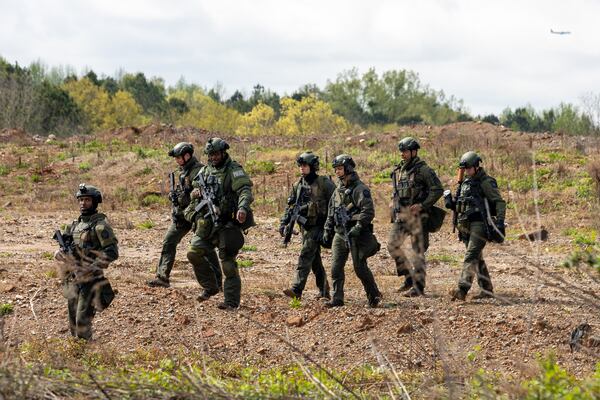 A police team walks through a land swap area near Intrenchment Creek Park in Atlanta on Monday, March 27, 2023. Agencies from across metro Atlanta, along with state agencies, were conducting a clearing operation of Intrenchment Creek Park led by DeKalb County Police. (i(Arvin Temkar / arvin.temkar@ajc.com)