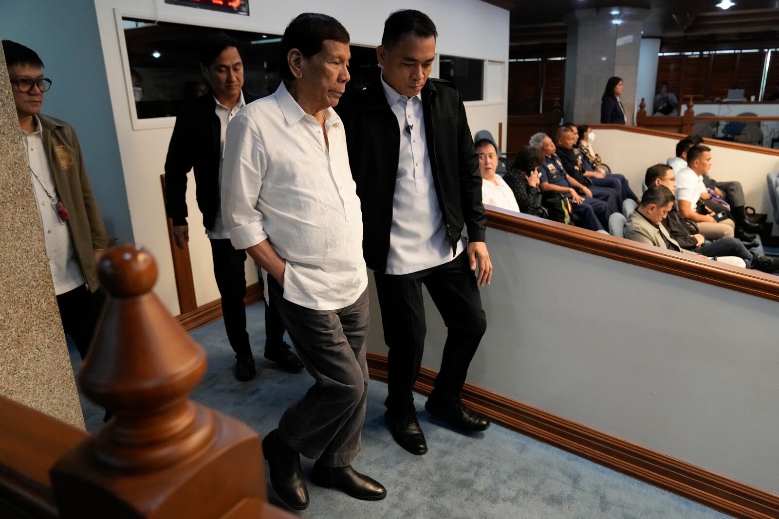 Former Philippine President Rodrigo Duterte, left, walks during a senate inquiry on the so-called war on drugs during his administration at the Philippine Senate Monday, Oct. 28, 2024, in Manila, Philippines. (AP Photo/Aaron Favila)