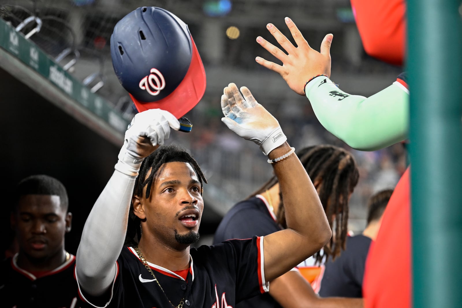 Washington Nationals' Jose Tena is congratulated by teammates in the dugout after scoring a run during the eighth inning of a baseball game against the Atlanta Braves, Wednesday, Sept. 11, 2024, in Washington. (AP Photo/John McDonnell)