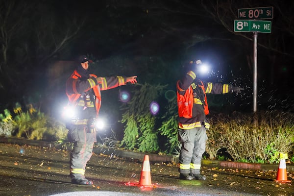 Seattle Fire Department personnel direct traffic off of NE 80th St. after power lines fell across the street during a major storm Tuesday, Nov. 19, 2024, in Seattle. (Jennifer Buchanan/The Seattle Times via AP)