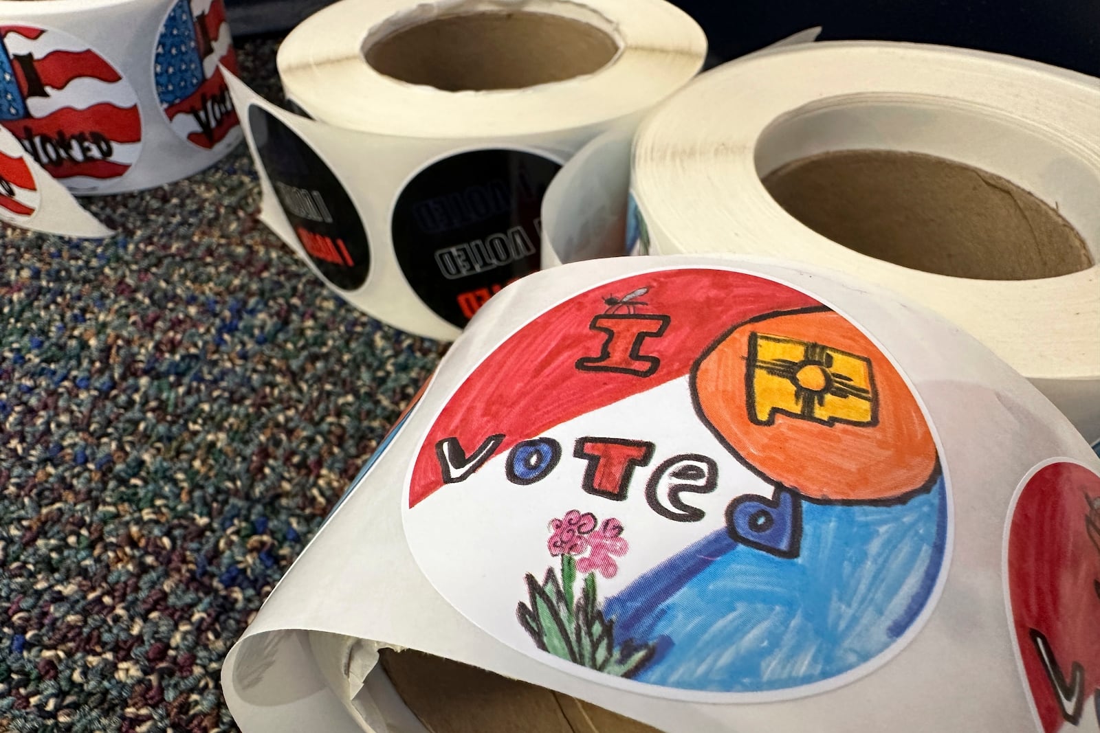 Rolls of I Voted stickers that were designed by students as part of a contest are stacked at an early voting center in Albuquerque, N.M., on Wednesday, Oct. 30, 2024. (AP Photo/Susan Montoya Bryan)