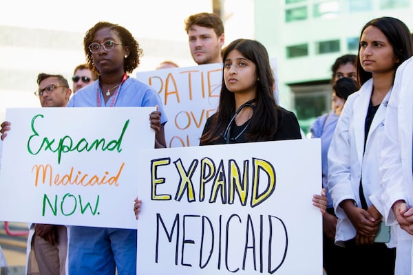 Healthcare professionals hold signs during a press conference on Tuesday, September 27, 2022, held by doctors and healthcare professionals concerned about the impact the coming closure of Atlanta Medical Center at Grady Hospital in Atlanta will have on Grady Memorial Hospital. Dr. Janice Bonsu, an orthopedic surgery resident at Grady who spoke at the event, is shown in the front row at left wearing blue scrubs. 
PHOTO by CHRISTINA MATACOTTA FOR THE ATLANTA JOURNAL-CONSTITUTION.
