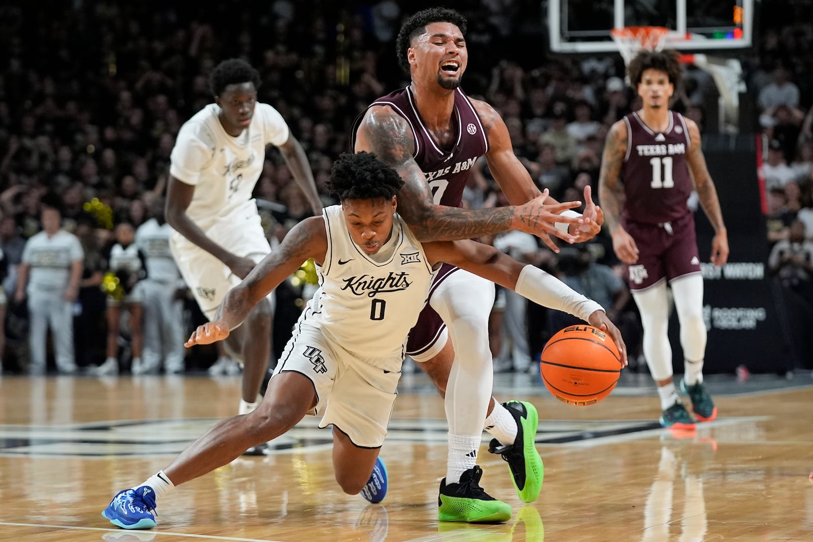 Central Florida guard Jordan Ivy-Curry (0) knocks the ball from the hands of Texas A&M guard Jace Carter, front right, during the first half of an NCAA college basketball game, Monday, Nov. 4, 2024, in Orlando, Fla. (AP Photo/John Raoux)