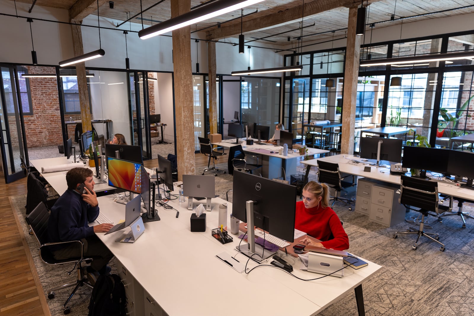 People work at Braden Fellman’s offices at Abrams Fixtures in Atlanta on Wednesday, October 16, 2024. The industrial building that housed several companies since 1920 was converted in 2019 into 33 residential lofts, 50,000 square feet of office space and about 8,000 square feet of restaurant space. (Arvin Temkar / AJC)