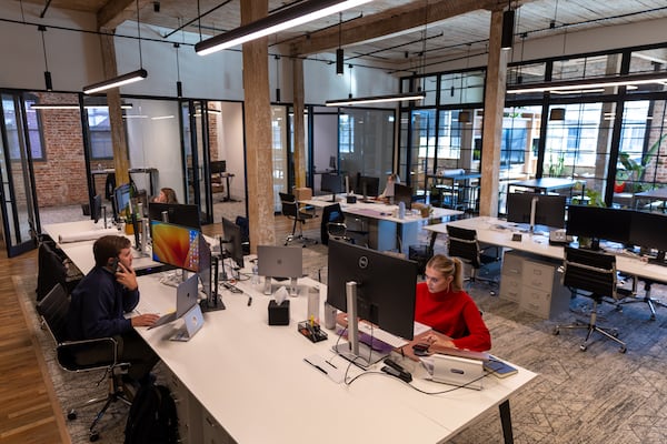 People work at Braden Fellman’s offices at Abrams Fixtures in Atlanta on Wednesday, October 16, 2024. The industrial building that housed several companies since 1920 was converted in 2019 into 33 residential lofts, 50,000 square feet of office space and about 8,000 square feet of restaurant space. (Arvin Temkar / AJC)