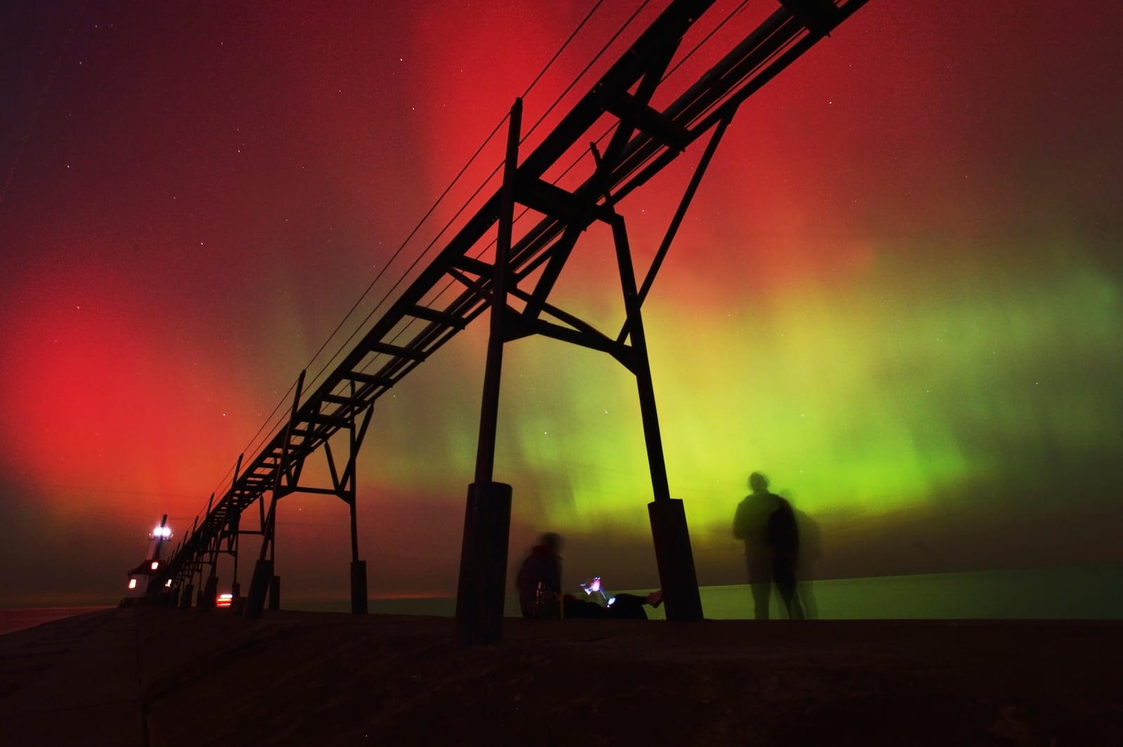 An aurora borealis, also known as the northern lights, lights up the night sky off Lake Michigan and the St. Joseph Lighthouse, Thursday, Oct. 10, 2024, in St. Joseph, Mich. (Don Campbell/The Herald-Palladium via AP)