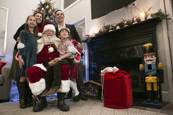 The Stafford family poses for a picture with Santa Claus (aka Judge T. Jackson Bedford) at a house Christmas party in Smyrna. The party is at a longtime friend’s house. CASEY SYKES / FOR THE ATLANTA JOURNAL-CONSTITUTION