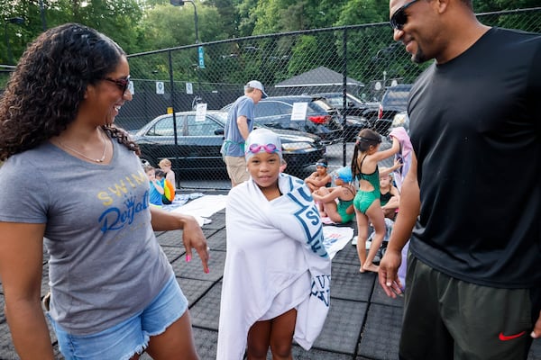 Maritza Correia Mcclendon (left), an Olympic medalist who now promotes swimming for blacks and hispanics, talks with her daughter, Sanaya, 8, along with Sanaya's father, Chad, after her race in a swim meet at Leslie Beach Club in Atlanta on Saturday, May 21, 2022.   (Bob Andres / robert.andres@ajc.com)