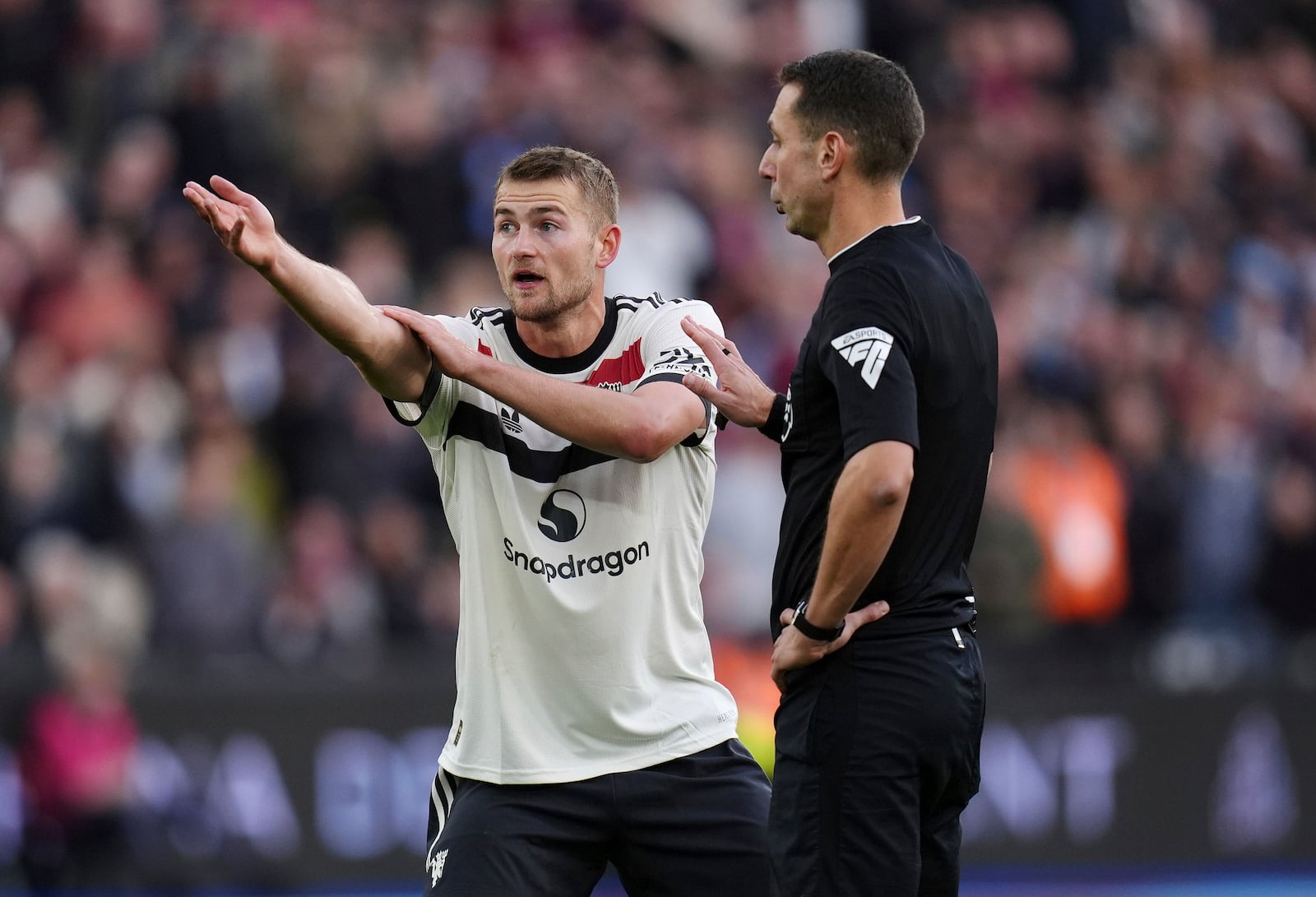 Manchester United's Matthijs de Ligt (left) protests to referee David Coote after he awards a penalty to West Ham United during the English Premier League soccer match between West Ham United and Manchester United at the London Stadium in London, Sunday, Oct. 27, 2024. (John Walton/PA via AP)