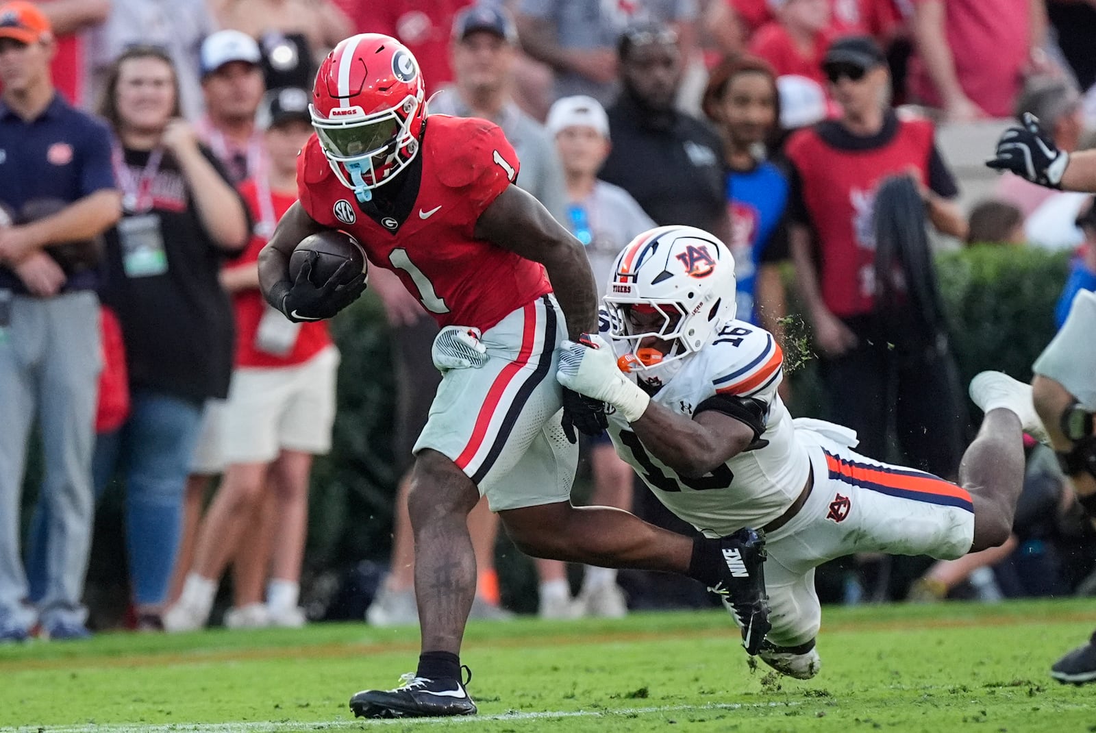 Georgia running back Trevor Etienne (1) tries to escape from Auburn linebacker Demarcus Riddick (16) after making a catch in the second half of an NCAA college football game Saturday, Oct. 5, 2024, in Athens, Ga. (AP Photo/John Bazemore)