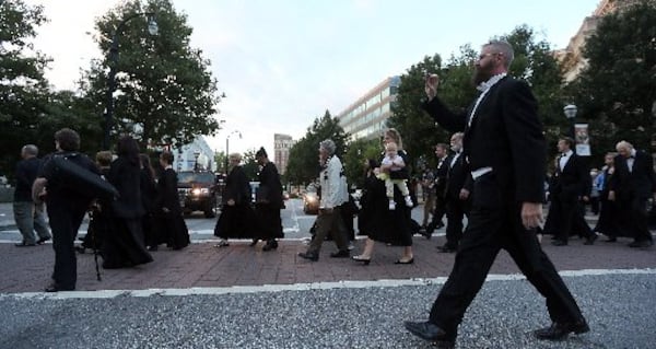 Musicians cross Peachtree Street on their way to a silent protest on what would have been opening night of the ASO's 70th anniversary season on Sept. 25. BEN GRAY / BGRAY@AJC.COM