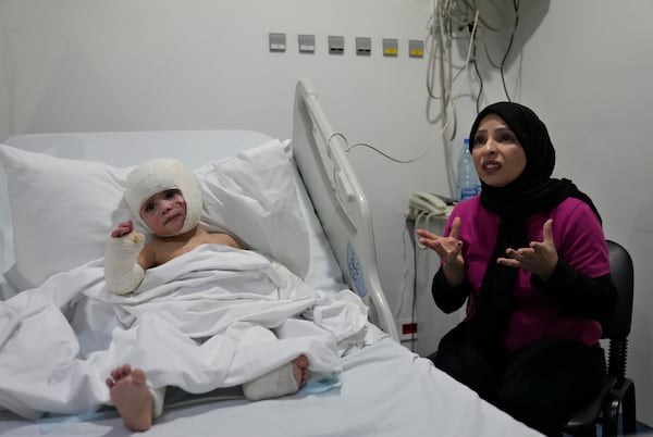 Fatima Zayoun, right, speaks during an interview with The Associated Press as she sits next to her daughter Ivana Skakye, 2, who is suffering from third-degree burns over 40 percent of her body following an Israeli airstrike last September near their home in Deir Qanoun al Nahr a village in south Lebanon, at the Geitaoui hospital where she is receiving treatment, in Beirut, Lebanon, Tuesday, Oct. 29, 2024. (AP Photo/Hussein Malla)