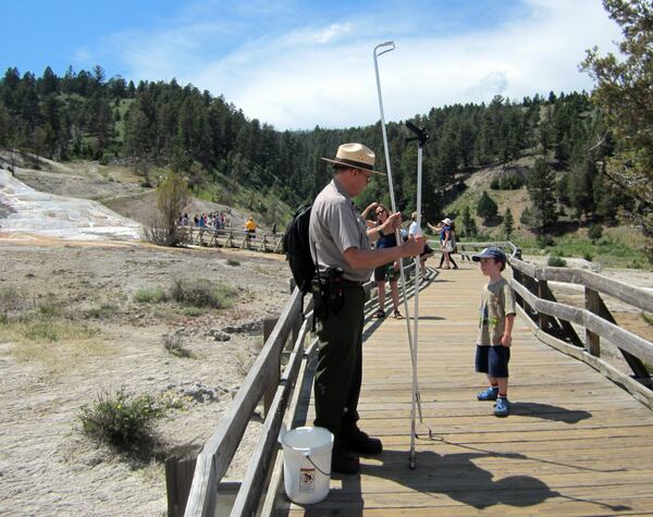 Ranger Wes Harding talks to a yong visitor while removing trash in Mammoth National Park. National Park Service photo by Cortney Adair