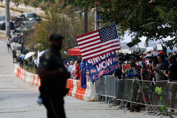 A crowd gathers Thursday behind orange barricades outside the Fulton County Jail on Rice Street ahead of the surrender of former President Donald Trump on charges of conspiracy to overturn the results of the 2020 election. (Miguel Martinez / miguel.martinez@ajc.com)