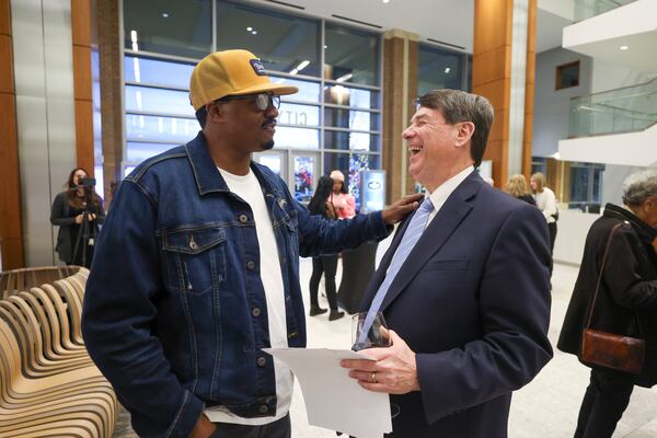 Artist Dakoro Edwards meets Sandy Springs mayor Rusty Paul before Edwards creates a live painting depicting Dexter King at Sandy Springs City Hall. (Jason Getz / jason.getz@ajc.com)