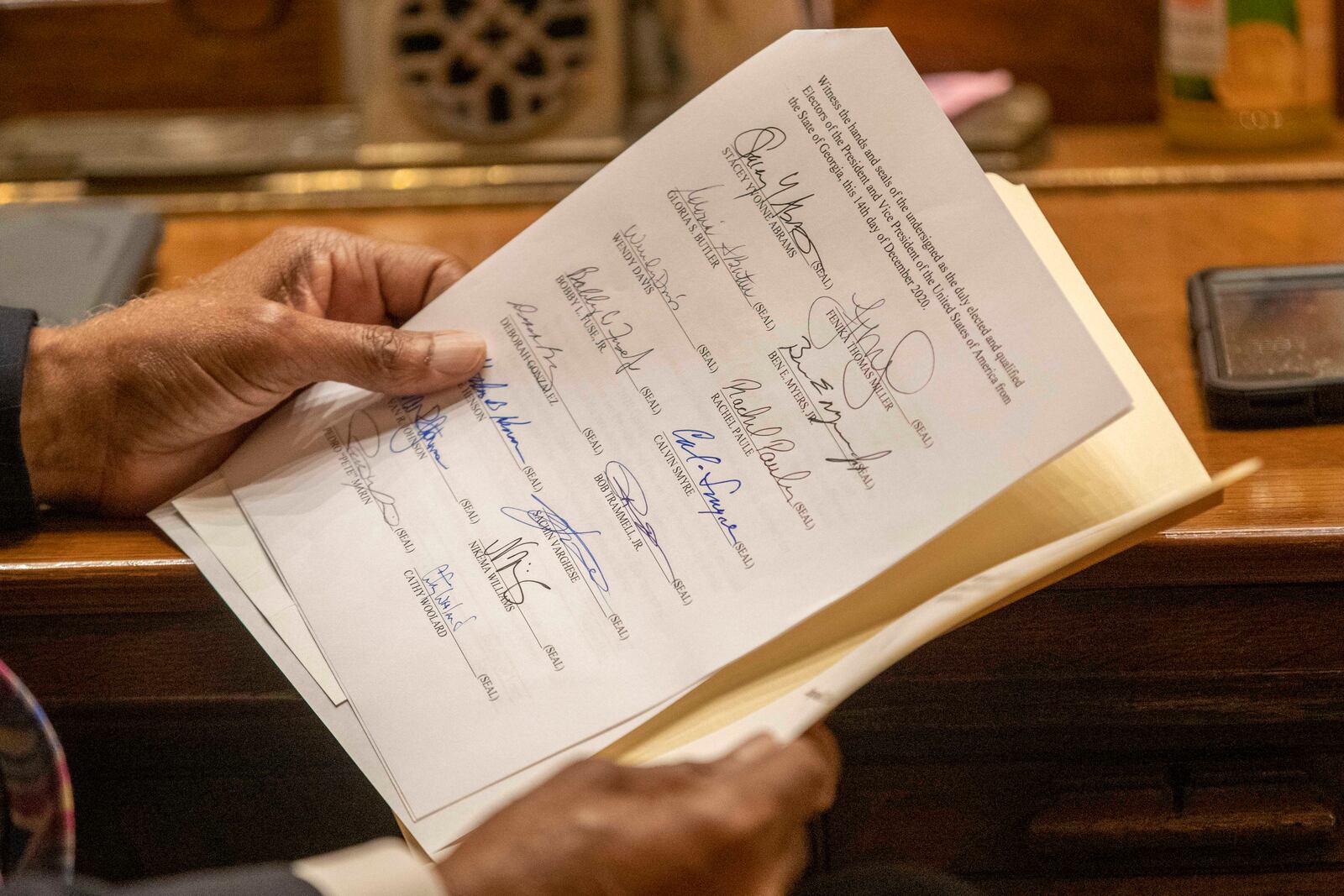 A member of the Georgia Electoral College looks over a Certificate of Vote during the official casting of the ballot in the Georgia Senate Chambers at the Georgia State Capitol building in Atlanta, Monday, December 14, 2020.  (Alyssa Pointer / AJC file photo)