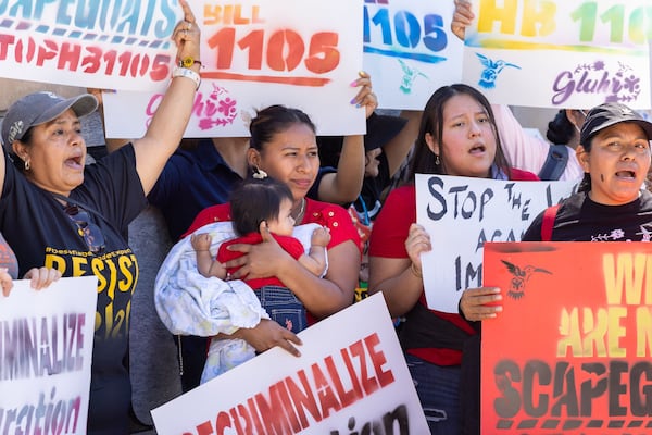 Immigrant rights activists protest HB 1105, which would would mandate that local law enforcement work more closely with ICE, at Liberty Plaza in front of the Capitol in May. (Arvin Temkar/AJC)