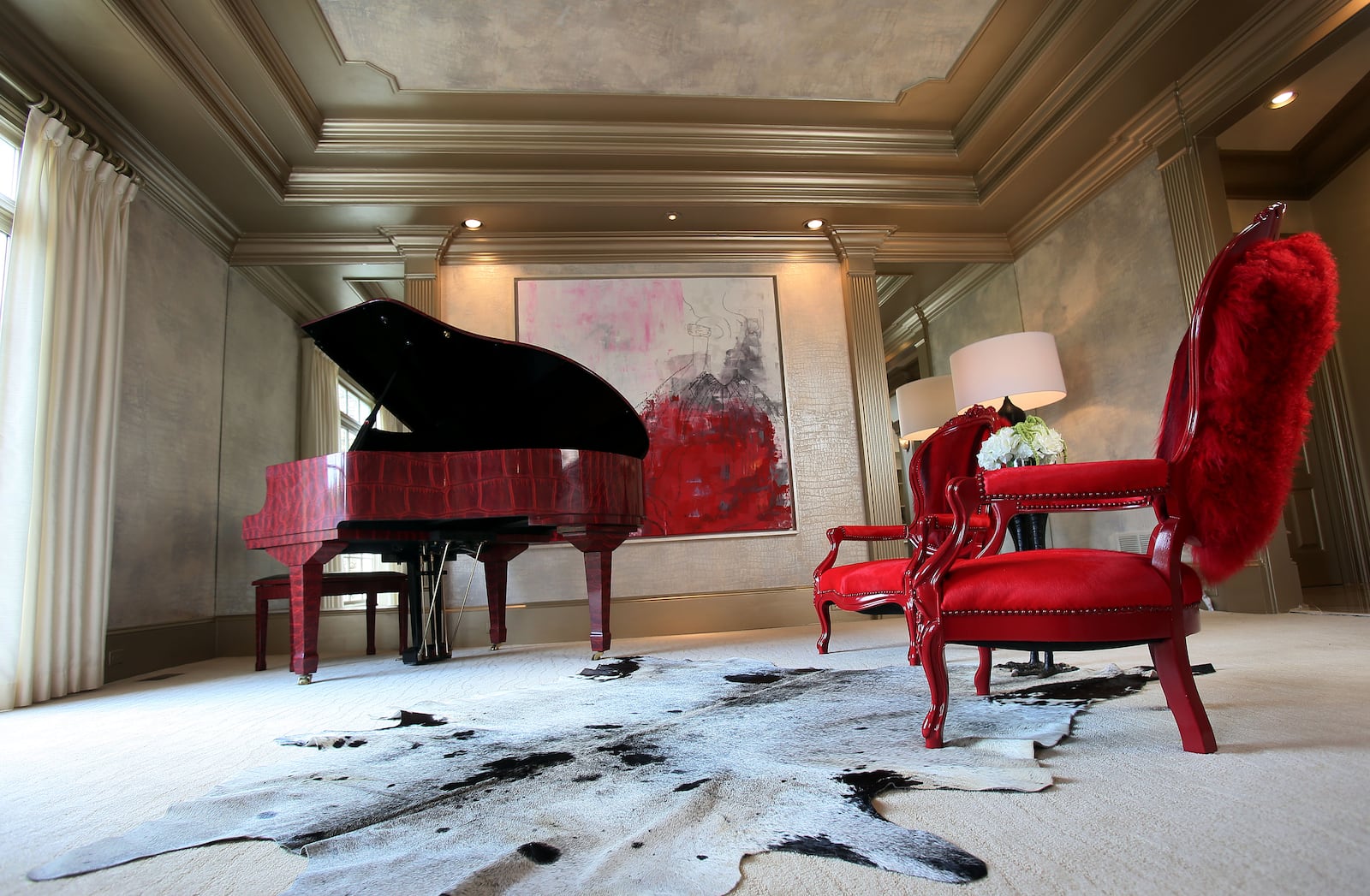 Burruss' piano room features red chairs, a crocodile-print piano and a custom painting.