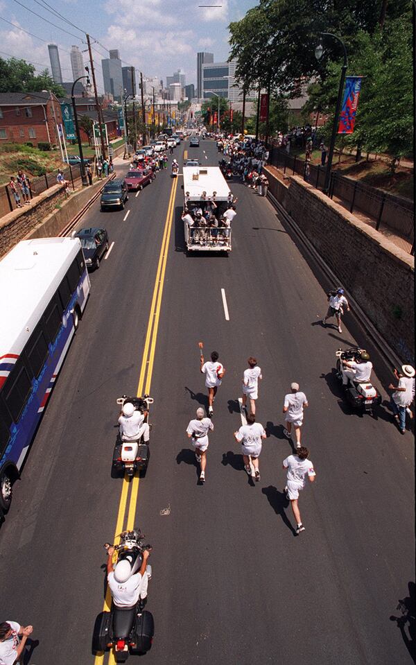 Torch runner travels under the Morris Brown College bridge, the same bridge that the coffin of Dr. Martin Luther King Jr. traveled under in 1968 as the torch finally made it's way into Atlanta, Georgia during the 1996 Summer Olympic Games. (AJC staff photo/John Spink) 07/19/96